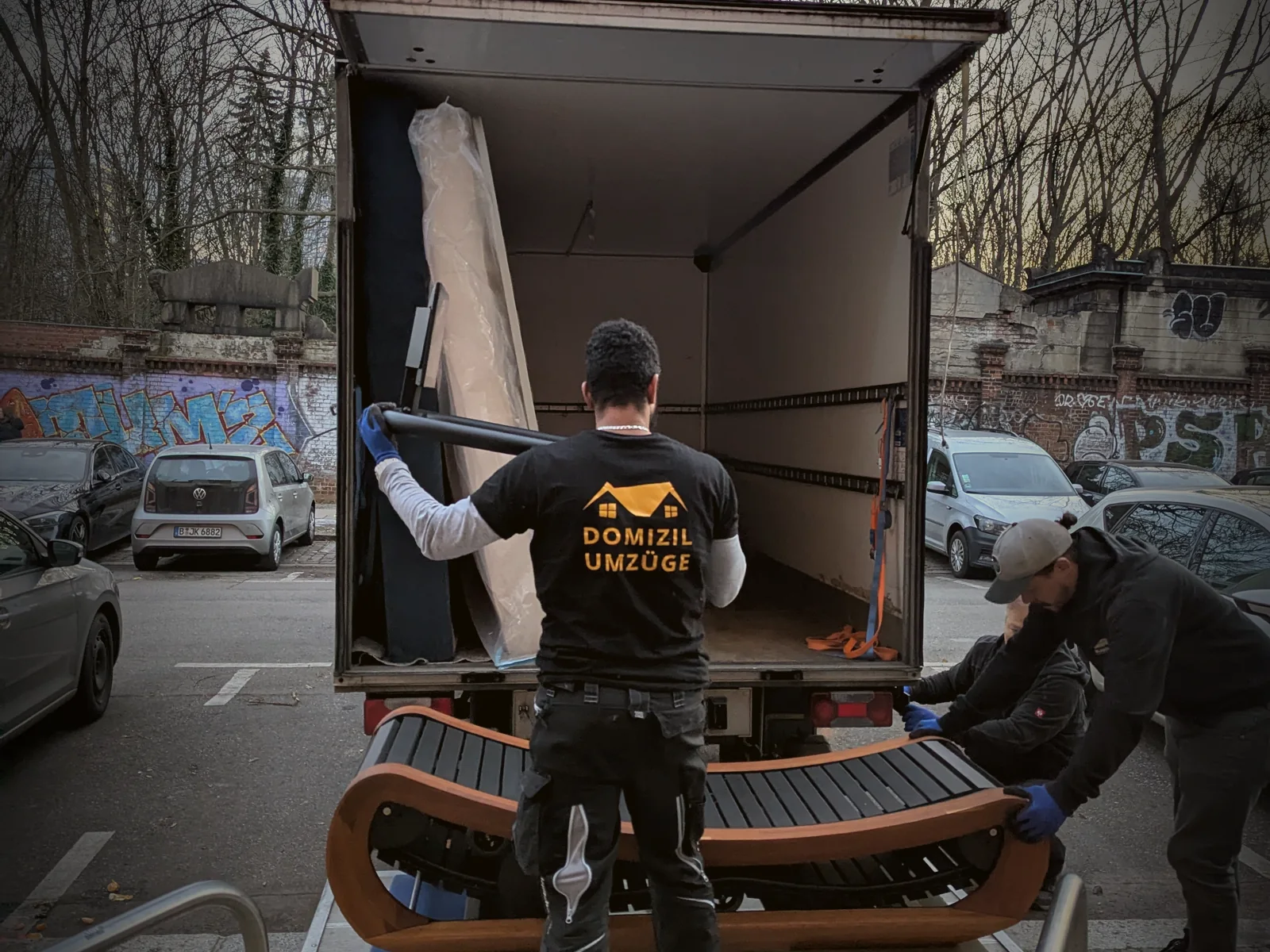 Ein Sofa wird über die Ladebordwand in den Umzugswagen gehoben